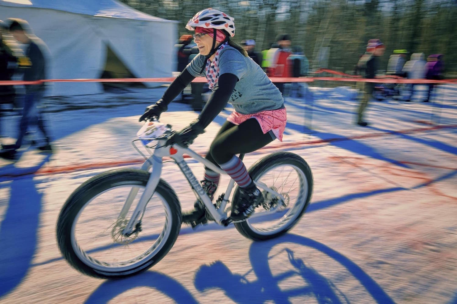 A race competitor celebrates Valentine's day while speeding down the course on her fat bike.