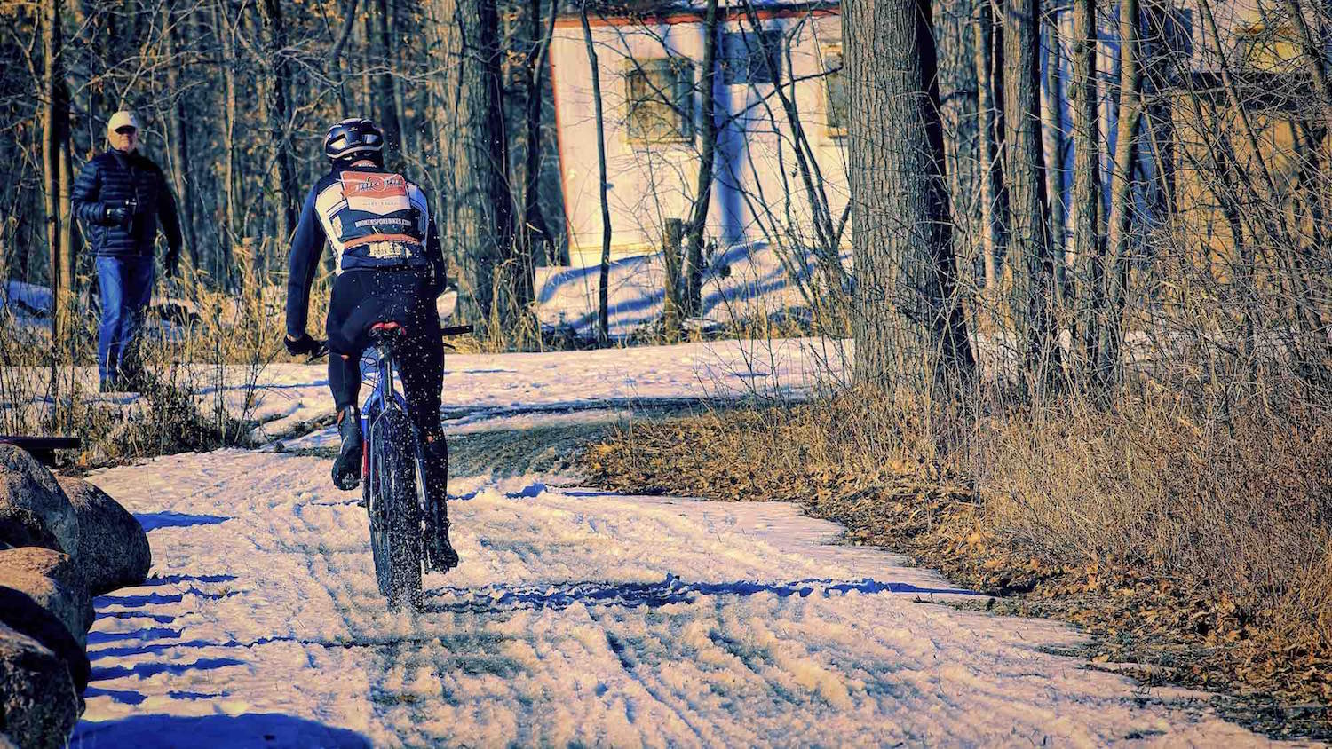 A fast racer leaves a rooster tail of snow in the wake of his fat bike.